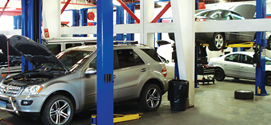 Fotografia del interior del taller de mecanica bcs. Demostrando autos en diferente niveles de reparacion.